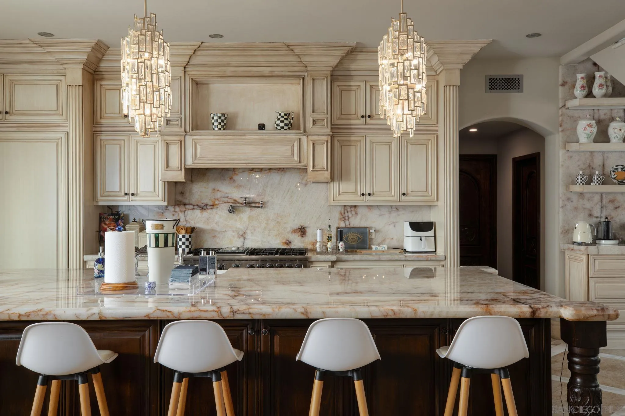 7853 Via Capri La Jolla, CA 92037 - Photo 33 of 67 a kitchen with stainless steel appliances granite countertop a kitchen island a stove a table and chairs in it