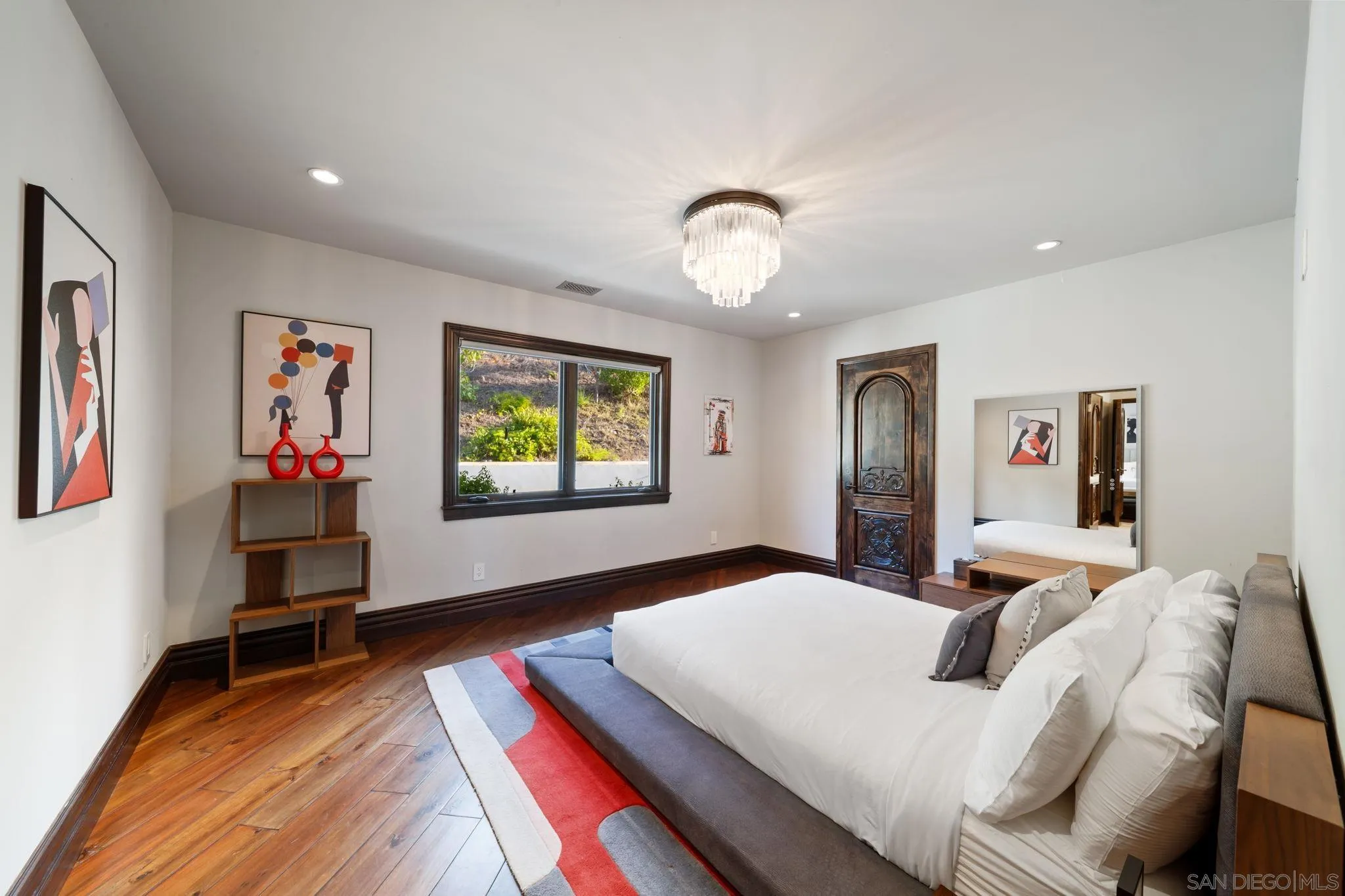 7853 Via Capri La Jolla, CA 92037 - Photo 40 of 67 a bedroom with a bed and a large mirror