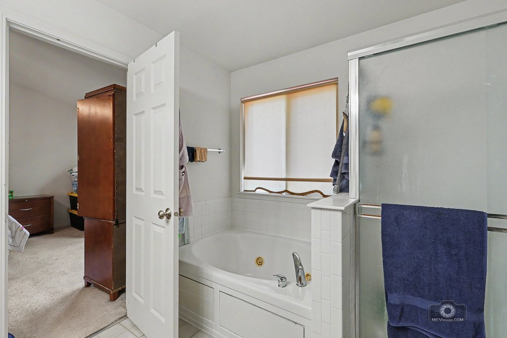 483 Elm Ridge Road Carpentersville, IL 60110 - Photo 22 of 31 a bathroom with a tub a sink and a large mirror