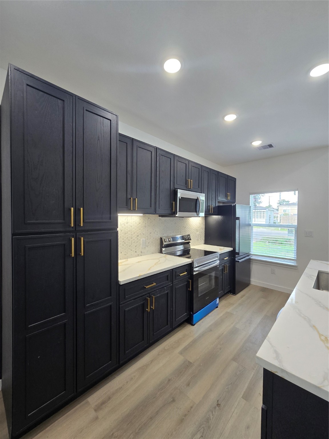 715 Rosedale Street La Marque, TX 77568 - Photo 5 of 14 a kitchen with stainless steel appliances granite countertop a refrigerator a sink dishwasher a stove and a refrigerator with wooden floor