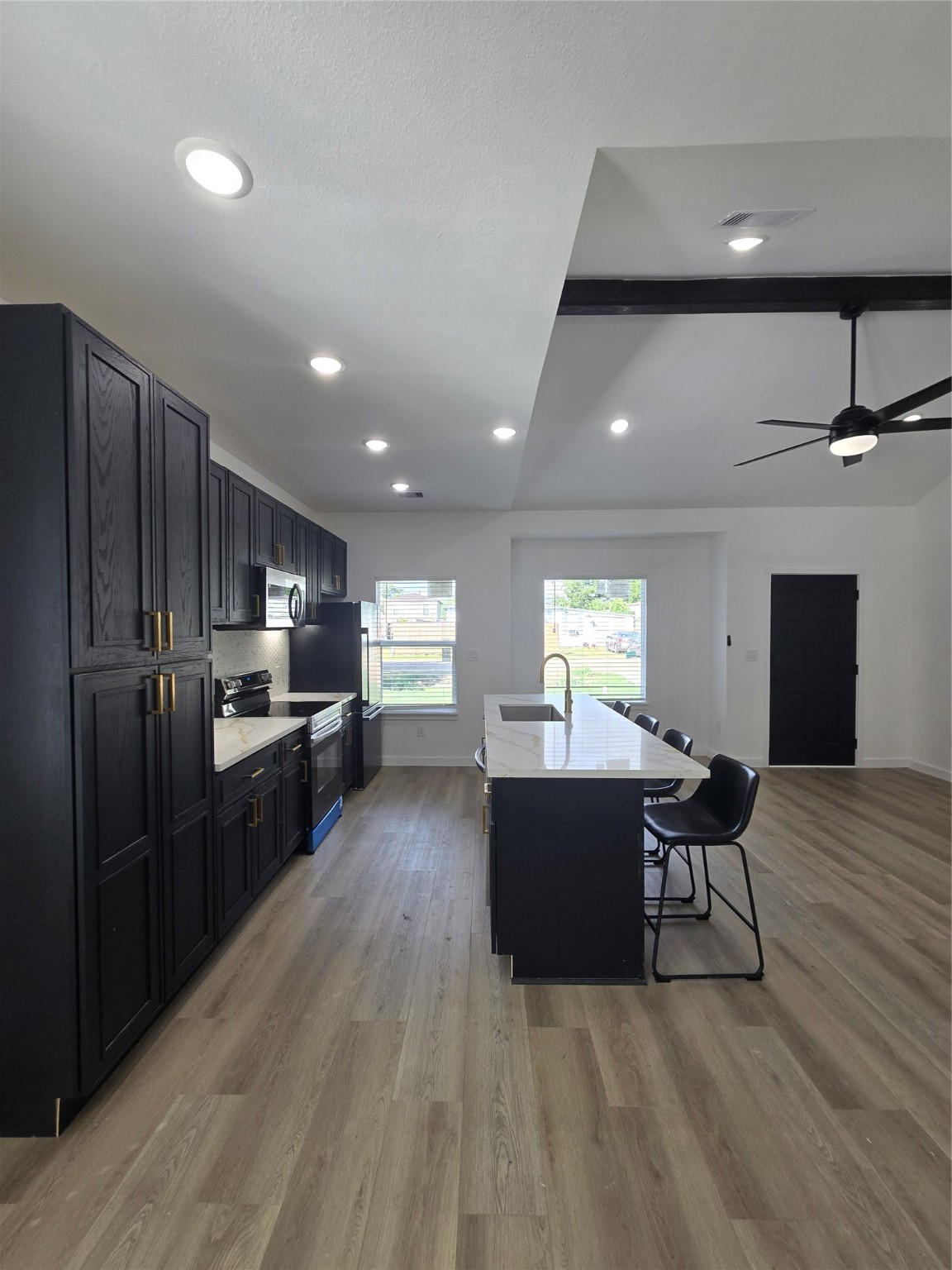 715 Rosedale Street La Marque, TX 77568 - Photo 6 of 14 a kitchen with stainless steel appliances kitchen island granite countertop a refrigerator a stove a sink dishwasher and a refrigerator with wooden floor