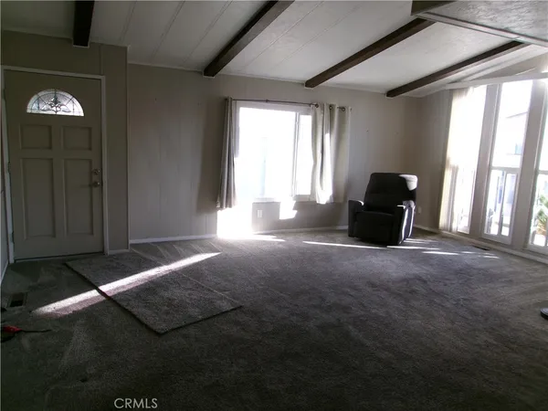 a view of a livingroom with an empty space and a window