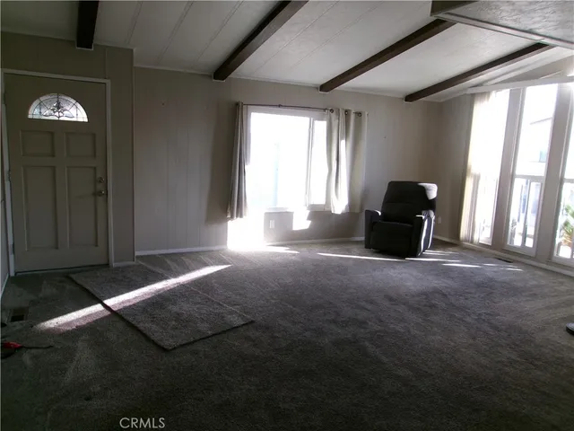 a view of a livingroom with an empty space and a window