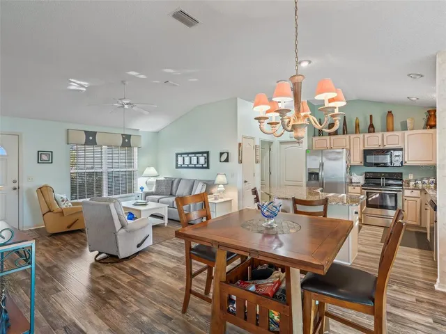 a view of a dining room with furniture wooden floor and chandelier