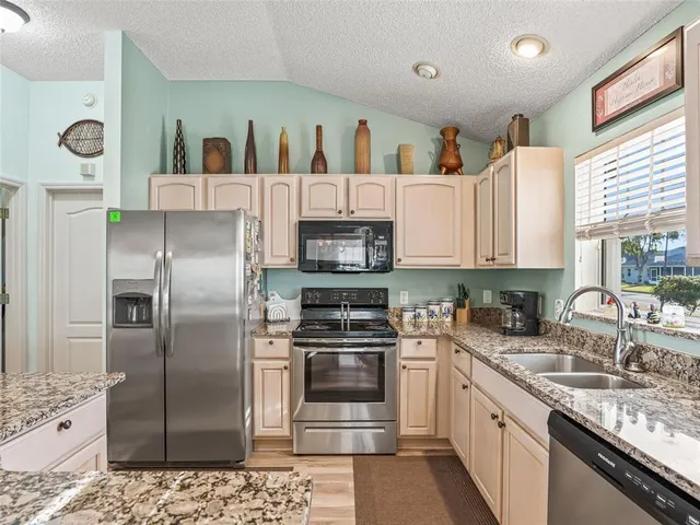 a kitchen with stainless steel appliances granite countertop a refrigerator sink and cabinets