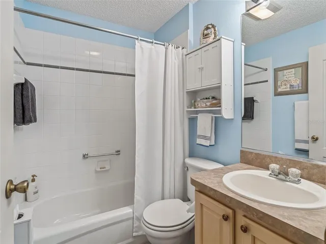 a bathroom with a sink toilet a mirror and shower