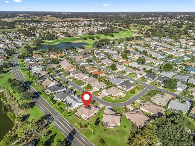 an aerial view of a residential houses with outdoor space and trees