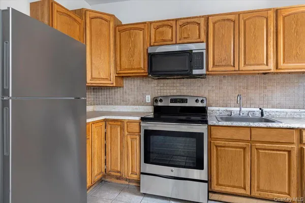 a kitchen with stainless steel appliances granite countertop white cabinets granite counter tops and a wooden floor