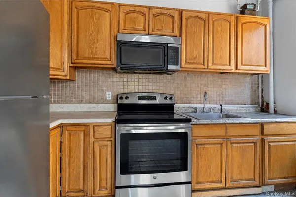 a kitchen with appliances a sink and cabinets