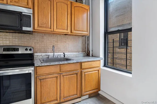 a kitchen with granite countertop cabinets stainless steel appliances and a sink