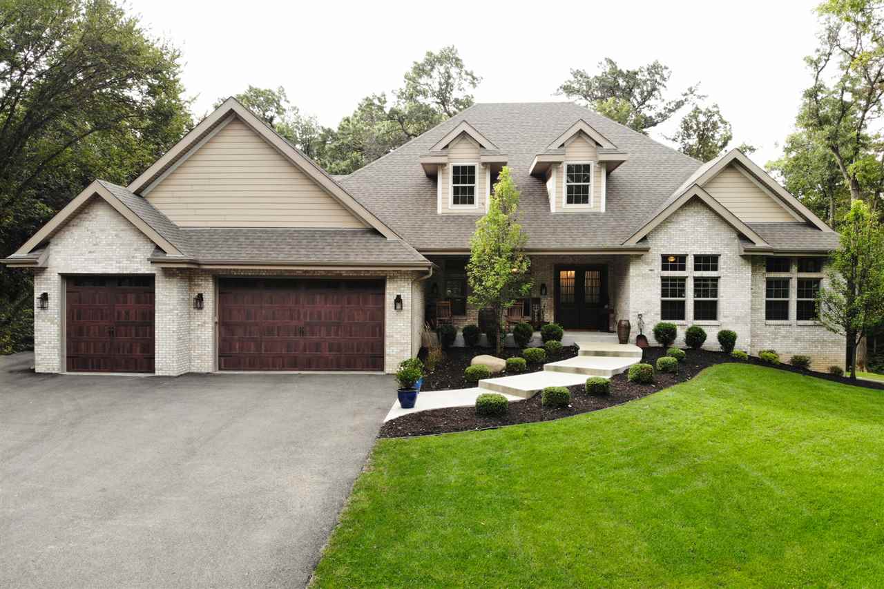 8745 Burr Oak Road Roscoe, IL 61073 - Photo 1 of 20 a front view of a house with a garden and trees