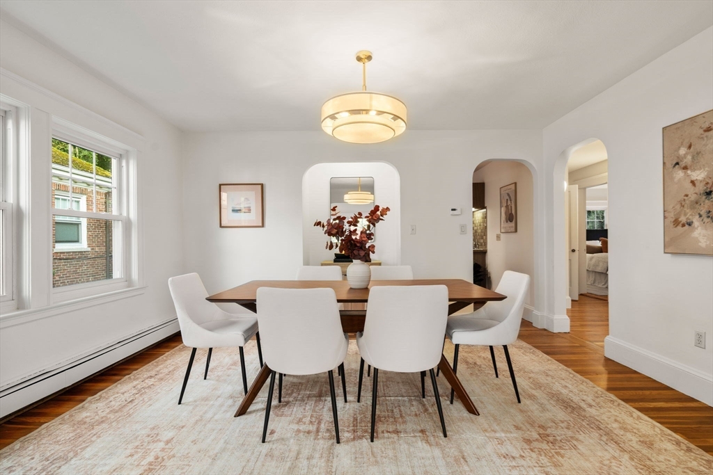 500 Washington Street, Unit 2 Brookline, MA 02445 - Photo 5 of 23 a dining room with wooden floor a chandelier a wooden table and chairs
