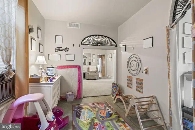 a living room with furniture and a clock on dresser