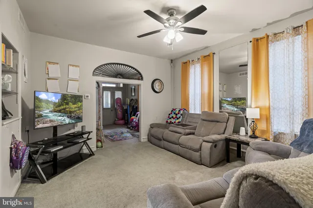 a living room with furniture a window and a flat screen tv