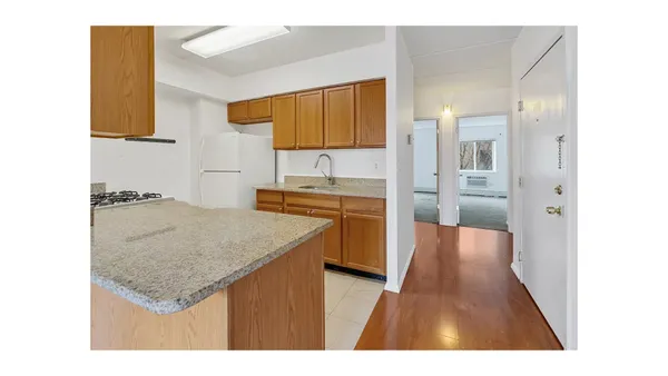 a kitchen with a sink refrigerator and cabinets