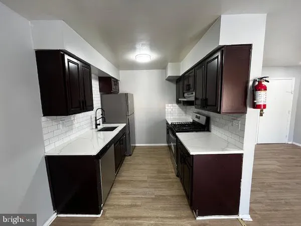 a kitchen with stainless steel appliances kitchen island granite countertop a refrigerator a sink and a stove