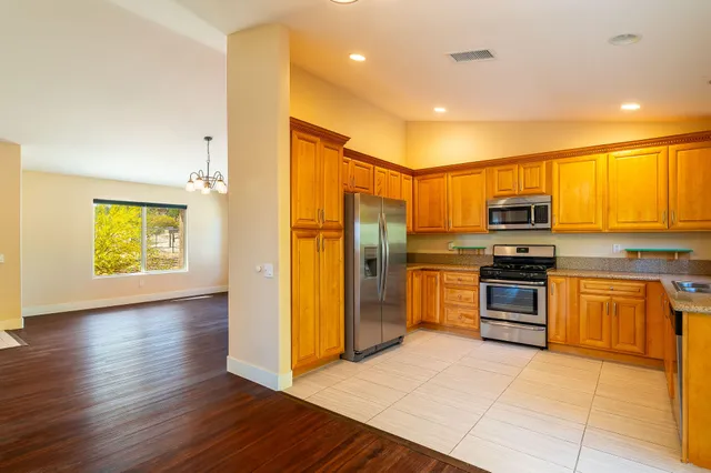 a kitchen with stainless steel appliances granite countertop a refrigerator and a stove top oven