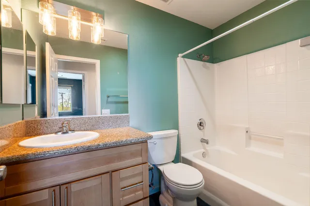 a bathroom with a granite countertop sink toilet and shower