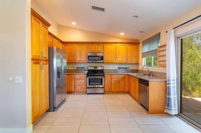 a kitchen with stainless steel appliances granite countertop a refrigerator and a sink