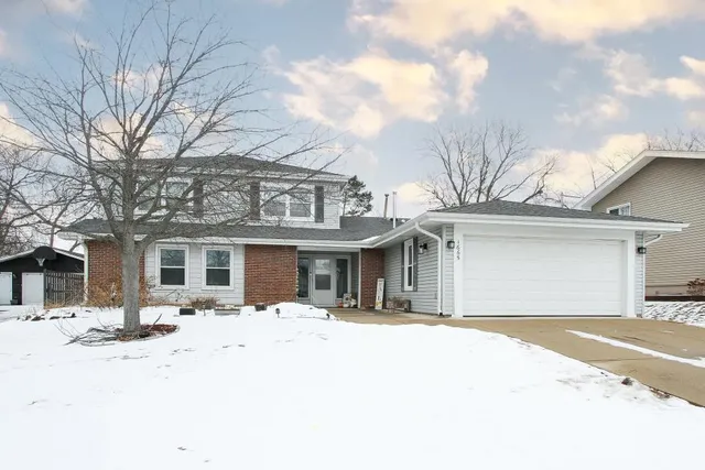 a front view of a house with a yard covered in snow