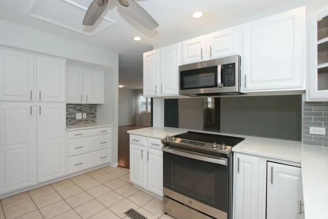 a kitchen with stainless steel appliances white cabinets and stove