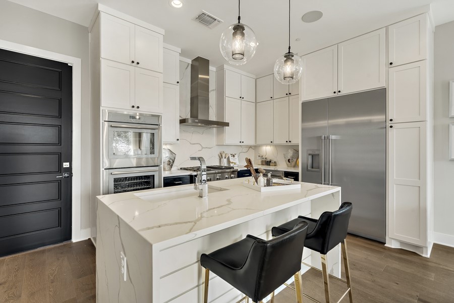 4206 Endurance Way Austin, TX 78731 - Photo 12 of 28 a kitchen with stainless steel appliances a stove a sink island and a refrigerator
