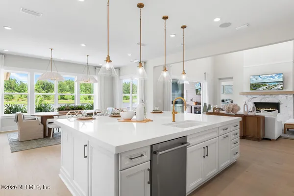 a view of a kitchen with kitchen island a stove a sink a center island a stove and a window