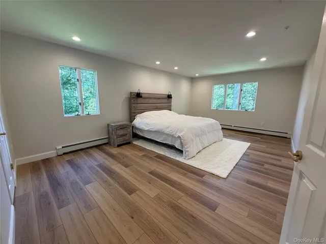 a spacious bedroom with a bed and a wooden floor