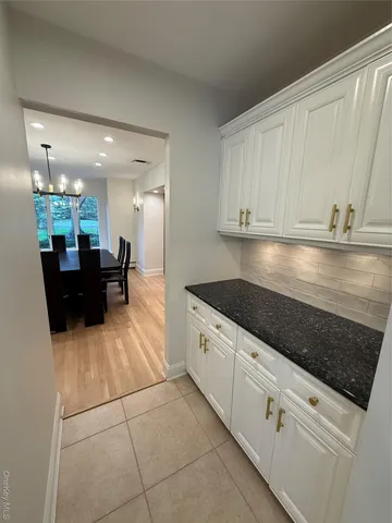 a view of swimming pool with wooden deck and trees in the background