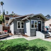 a view of a house with furniture and a garden