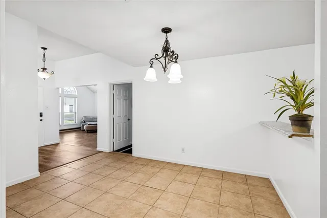 a view of a livingroom with wooden floor and a chandelier