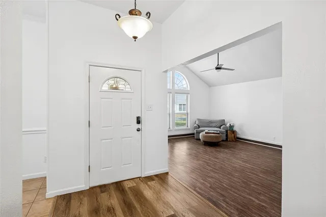 a view of a livingroom with wooden floor and a ceiling fan