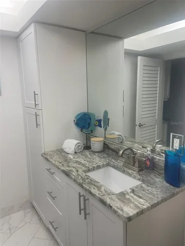 a bathroom with a granite countertop sink and a mirror