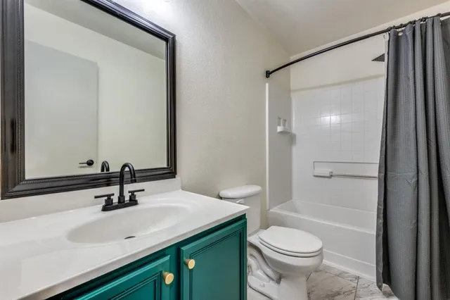 a bathroom with a sink a toilet and shower a mirror