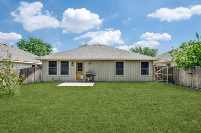 a front view of a house with a garden and trees