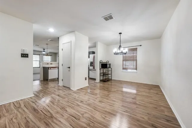 a view of a kitchen with a refrigerator wooden floor and a window