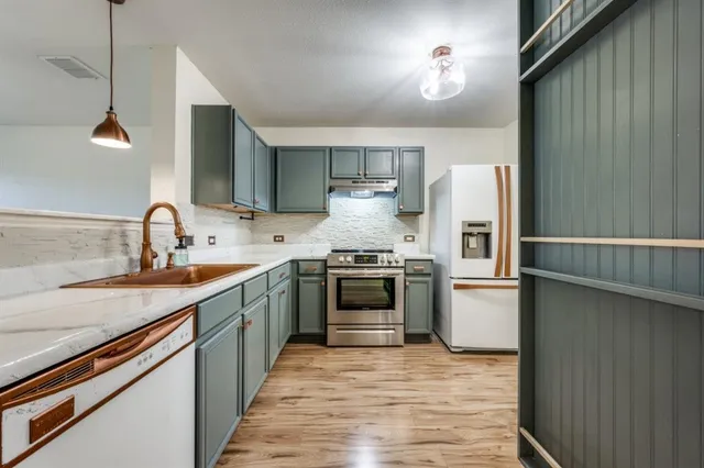 a kitchen with stainless steel appliances granite countertop a sink stove and refrigerator