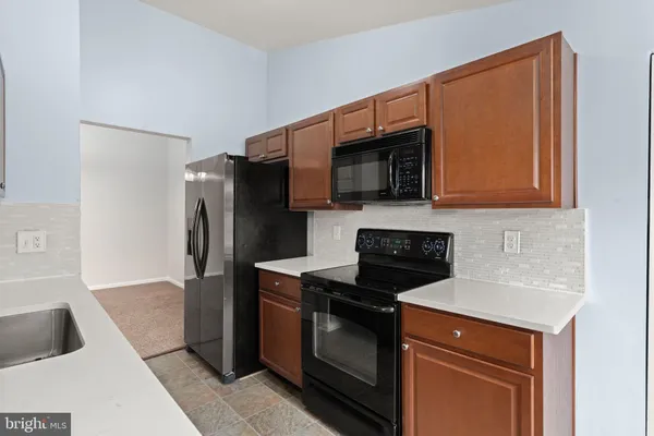 a kitchen with stainless steel appliances wooden cabinets sink and microwave