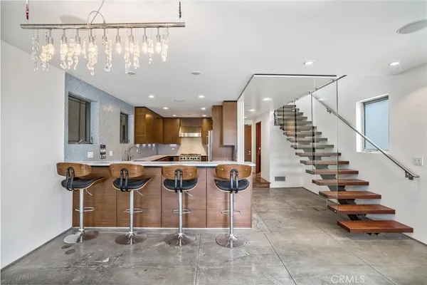 a view of a room with lots of wooden furniture and a chandelier