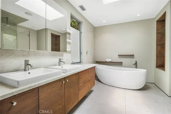 a bathroom with a double vanity sink mirror and bathtub