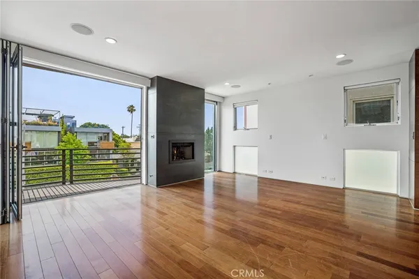 an empty room with wooden floor and fireplace