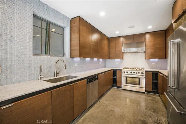 a kitchen with stainless steel appliances granite countertop a sink stove and refrigerator