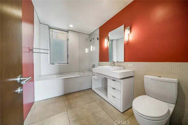 a bathroom with a toilet a sink a mirror and vanity