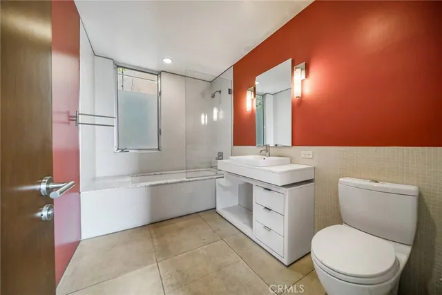 a bathroom with a toilet a sink a mirror and vanity
