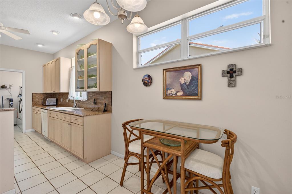4266 Summertree Road Venice, FL 34293 - Photo 17 of 64 a dining room with wooden floor and a chandelier