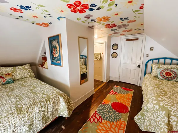 a bedroom with bed and wooden floor