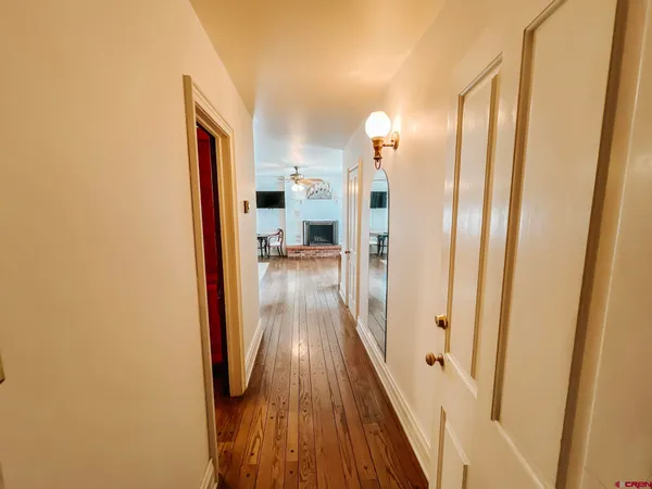 a view of a hallway with wooden floor
