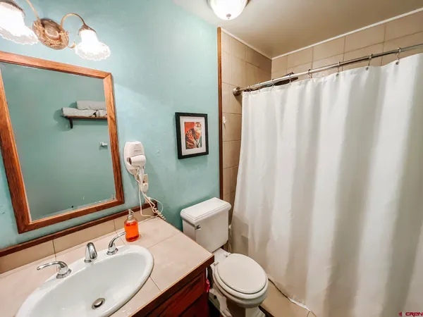 a bathroom with a sink a toilet and shower curtain