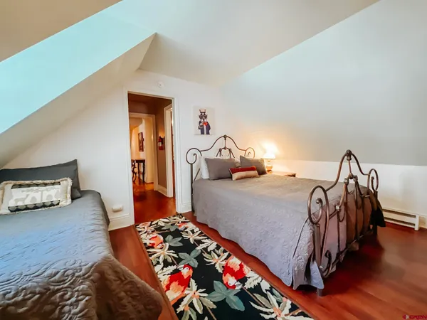 a bedroom with bed and wooden floor