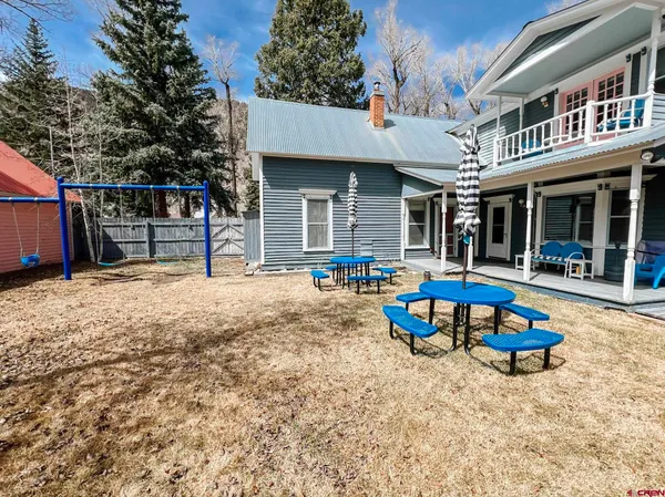 a view of a house with backyard and sitting area